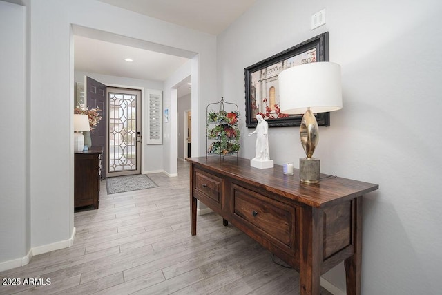 foyer entrance featuring light wood-style floors, visible vents, and baseboards