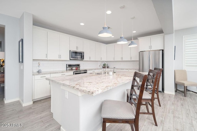 kitchen featuring light wood-type flooring, white cabinetry, and appliances with stainless steel finishes