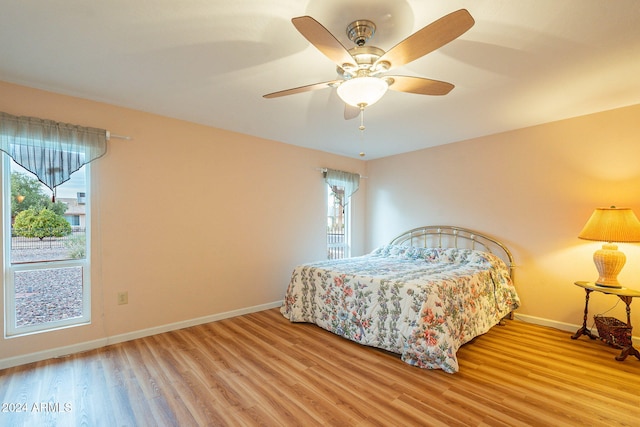 bedroom with multiple windows, light wood-type flooring, and ceiling fan