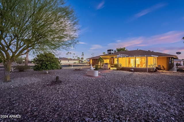 back house at dusk with a patio area