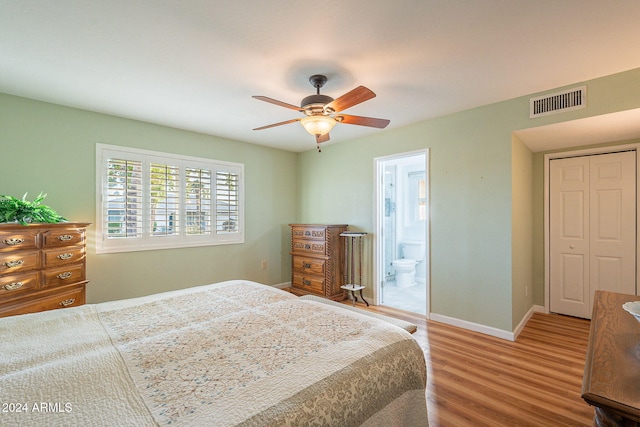 bedroom featuring ensuite bath, wood-type flooring, a closet, and ceiling fan