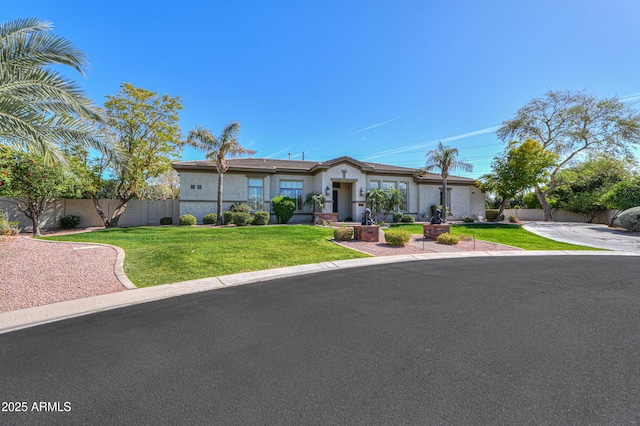 view of front of property with fence, a front lawn, and stucco siding