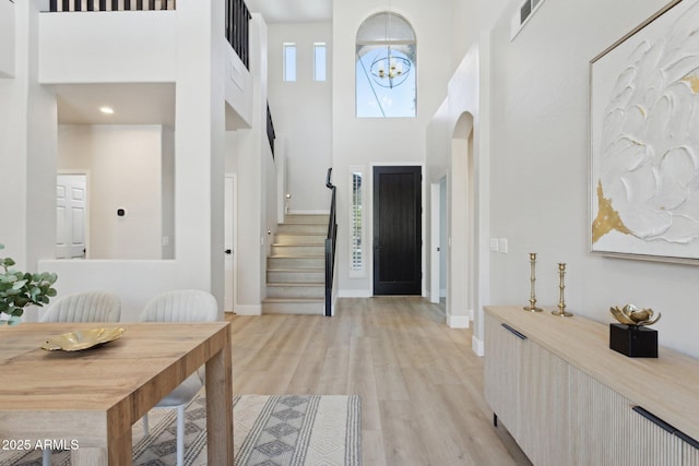 3202 E Orange Dr, Phoenix, AZ 85018 - entrance foyer with a towering ceiling, stairs, light wood-type flooring, baseboards, and arched walkways