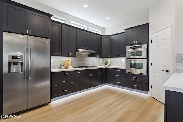 3202 E Orange Dr, Phoenix, AZ 85018 - kitchen with stainless steel appliances, light wood-type flooring, tasteful backsplash, under cabinet range hood, and recessed lighting