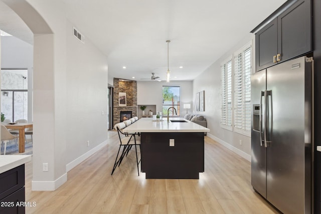 3202 E Orange Dr, Phoenix, AZ 85018 - kitchen featuring stainless steel refrigerator with ice dispenser, open floor plan, ceiling fan, a sink, and a fireplace