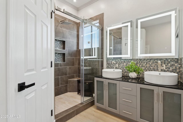 3202 E Orange Dr, Phoenix, AZ 85018 - full bathroom featuring a stall shower, double vanity, wood finished floors, crown molding, and decorative backsplash