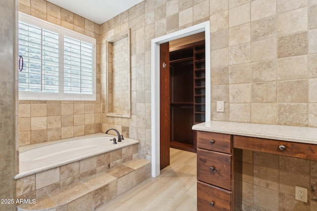 3202 E Orange Dr, Phoenix, AZ 85018 - full bath featuring a bath, tile walls, wood finished floors, and a walk in closet