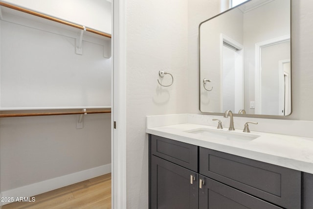 3202 E Orange Dr, Phoenix, AZ 85018 - bathroom featuring wood finished floors, vanity, baseboards, and a walk in closet