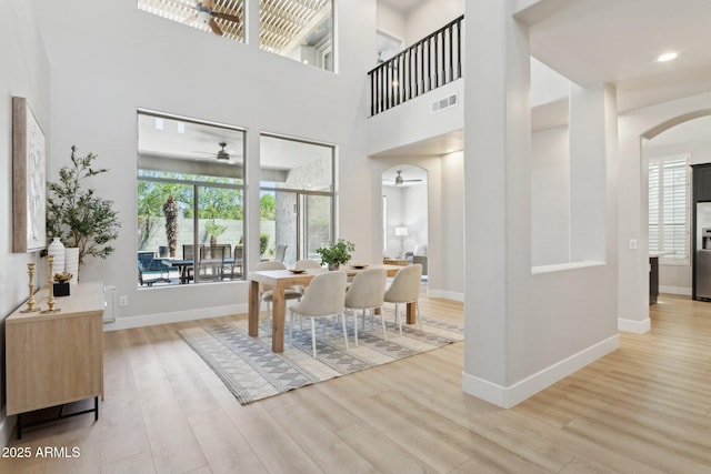 3202 E Orange Dr, Phoenix, AZ 85018 - dining area with ceiling fan, wood finished floors, arched walkways, baseboards, and a towering ceiling