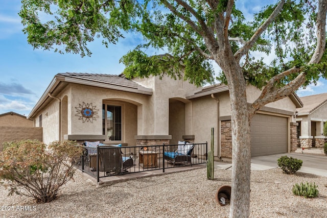 view of front facade featuring fence, a tile roof, concrete driveway, stucco siding, and an attached garage