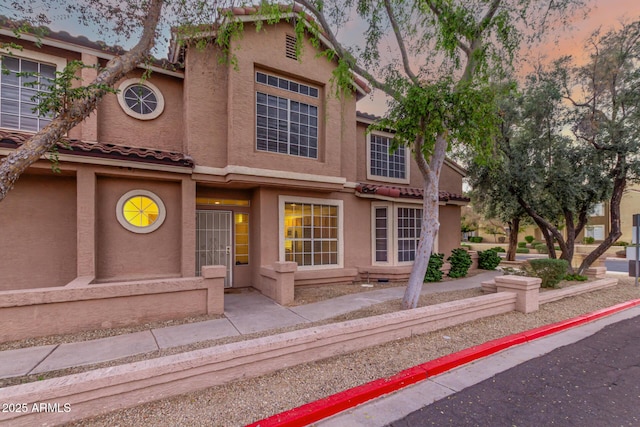 view of front of property featuring a tile roof and stucco siding