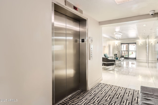 hall featuring light tile patterned floors and elevator