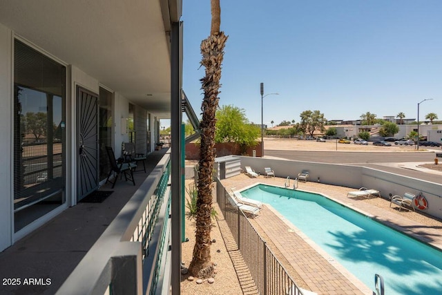 view of swimming pool featuring fence