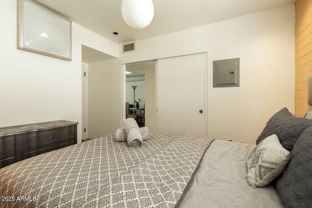 bedroom with electric panel and a closet