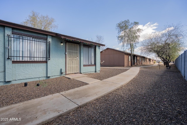 view of front of house with fence and stucco siding