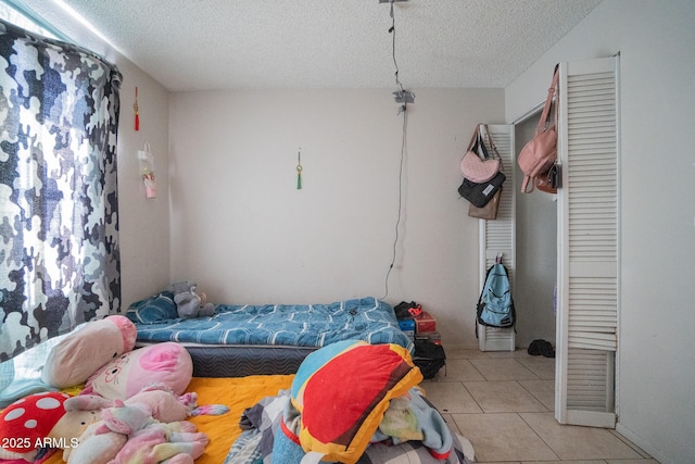 bedroom featuring light tile patterned floors and a textured ceiling