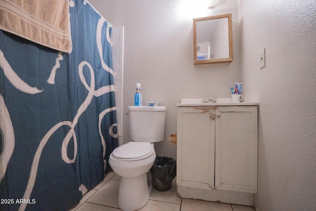 bathroom with vanity, tile patterned flooring, curtained shower, toilet, and a textured wall