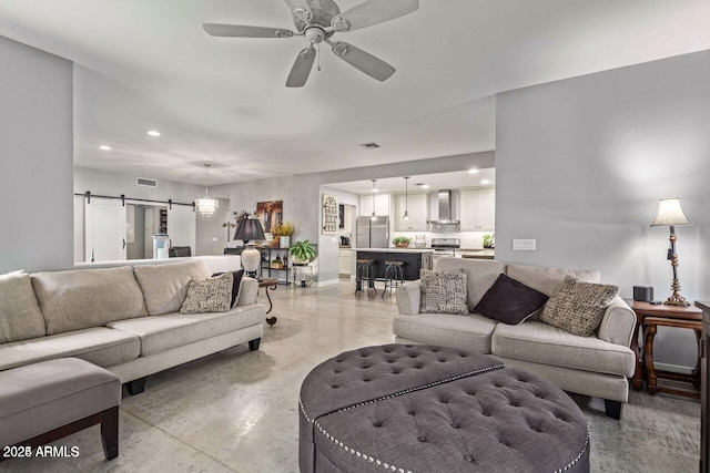 living room featuring a barn door and ceiling fan