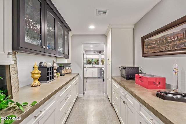 bar featuring dishwasher, dark brown cabinetry, white cabinetry, and a brick fireplace