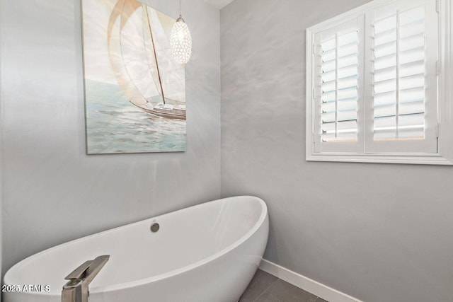 bathroom with tile patterned flooring and a tub