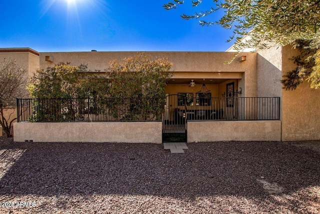 rear view of property with ceiling fan