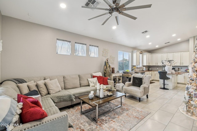 living room featuring light tile patterned floors, vaulted ceiling, and ceiling fan