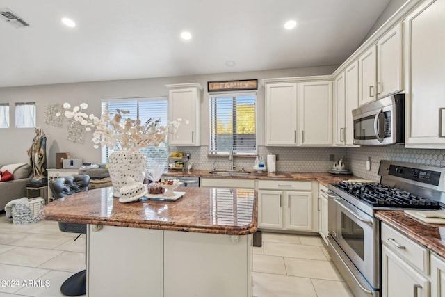 kitchen with light tile patterned floors, stainless steel appliances, white cabinetry, and sink