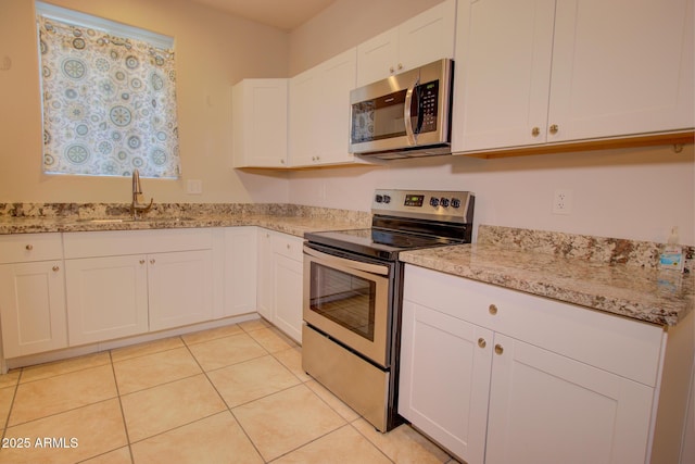 kitchen featuring light stone counters, sink, white cabinetry, and stainless steel appliances