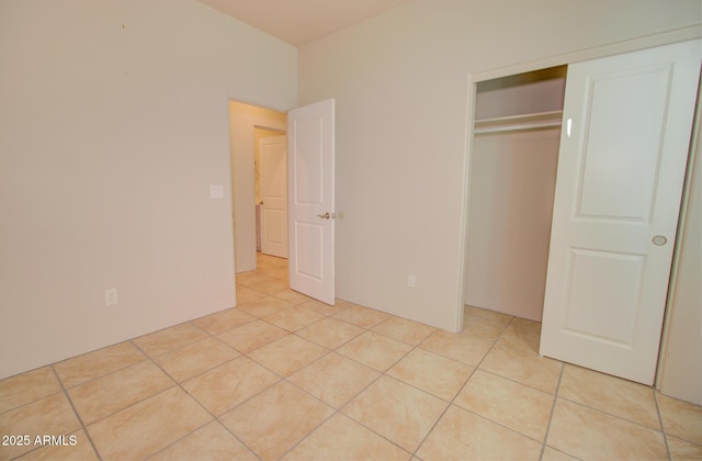 unfurnished bedroom with light tile patterned floors and a closet