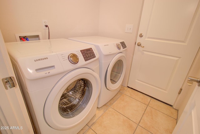 laundry area with washing machine and dryer and light tile patterned floors