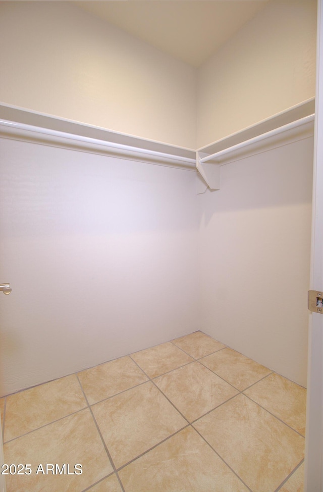 walk in closet with light tile patterned floors