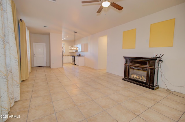 unfurnished living room featuring ceiling fan and light tile patterned flooring