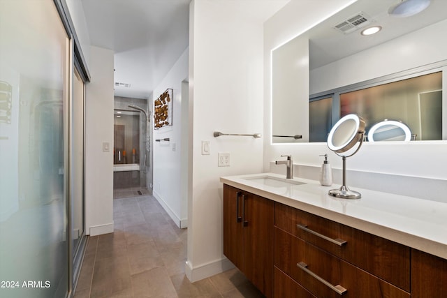 bathroom featuring vanity, tile patterned flooring, and a shower with door