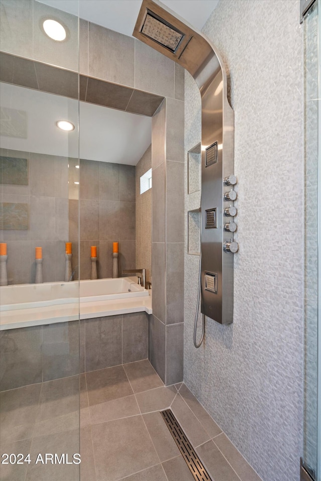 bathroom featuring tile walls, independent shower and bath, and tile patterned flooring