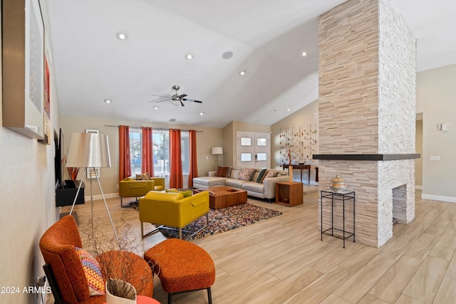 living room featuring high vaulted ceiling, a fireplace, light wood-type flooring, and ceiling fan