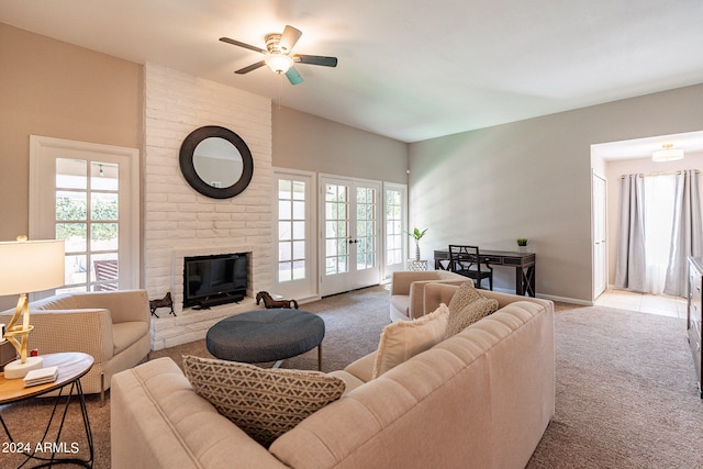 carpeted living room with ceiling fan, a fireplace, and a wealth of natural light