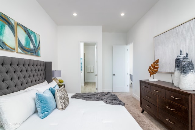 bedroom with light carpet and ensuite bathroom