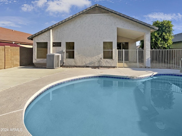 view of swimming pool featuring a patio and central air condition unit