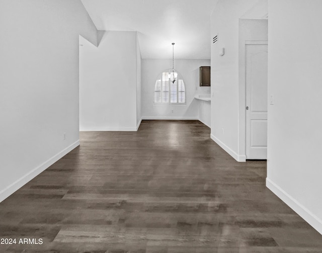 interior space featuring a notable chandelier and dark wood-type flooring