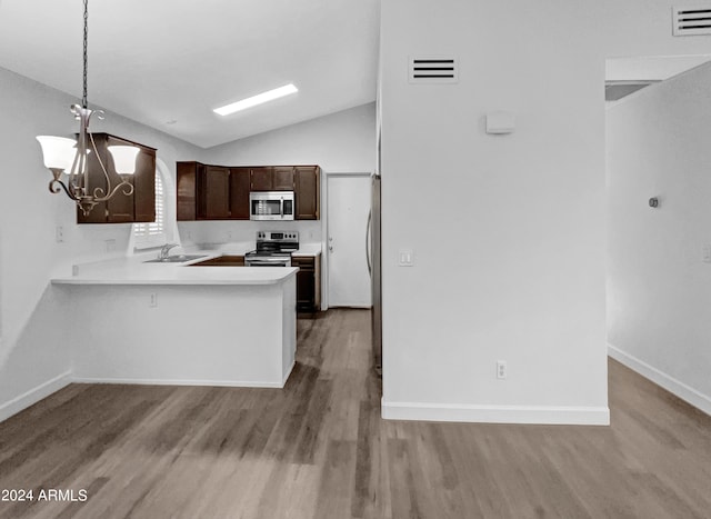 kitchen featuring sink, kitchen peninsula, pendant lighting, lofted ceiling, and appliances with stainless steel finishes