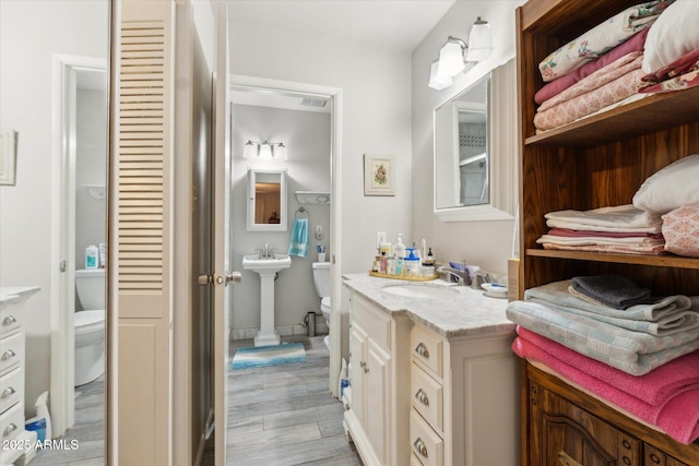 614 N Pioneer Cir, Mesa, AZ 85203 - bathroom featuring toilet, a sink, and wood finished floors