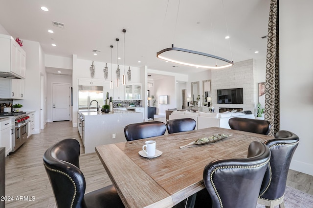 dining room featuring light wood-style floors, recessed lighting, and visible vents