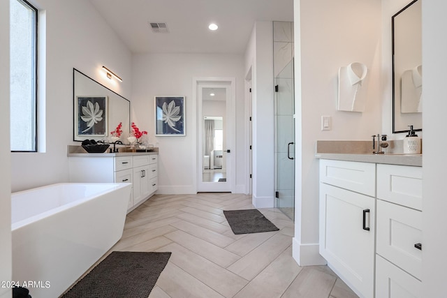 full bath with recessed lighting, two vanities, visible vents, a soaking tub, and a shower stall