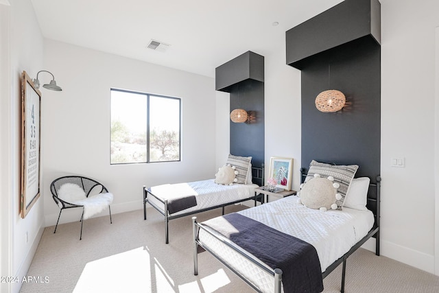 bedroom featuring baseboards, visible vents, and light colored carpet