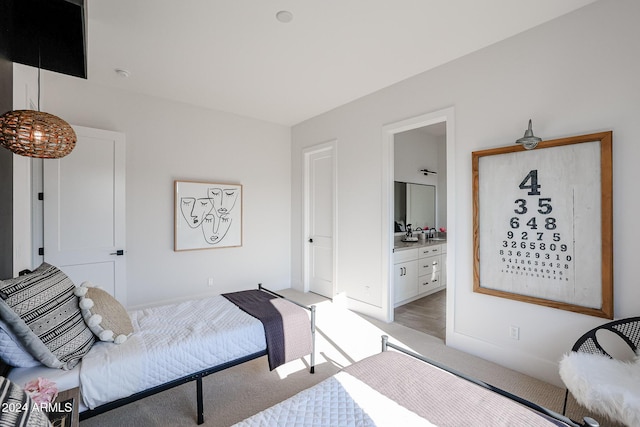 bedroom with ensuite bath and light colored carpet