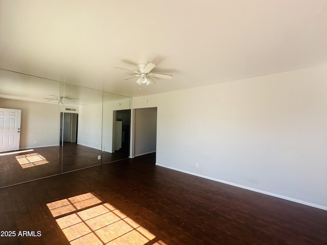 empty room with ceiling fan and dark hardwood / wood-style floors