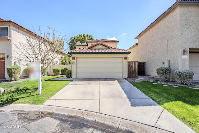 mediterranean / spanish house with stucco siding, a front lawn, concrete driveway, an attached garage, and a tiled roof