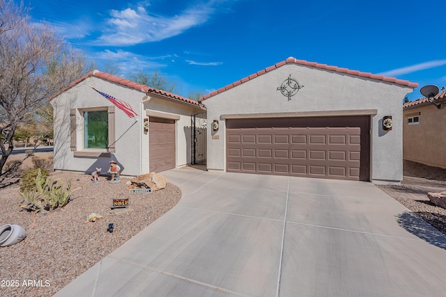 mediterranean / spanish-style home featuring a garage, driveway, a tile roof, and stucco siding