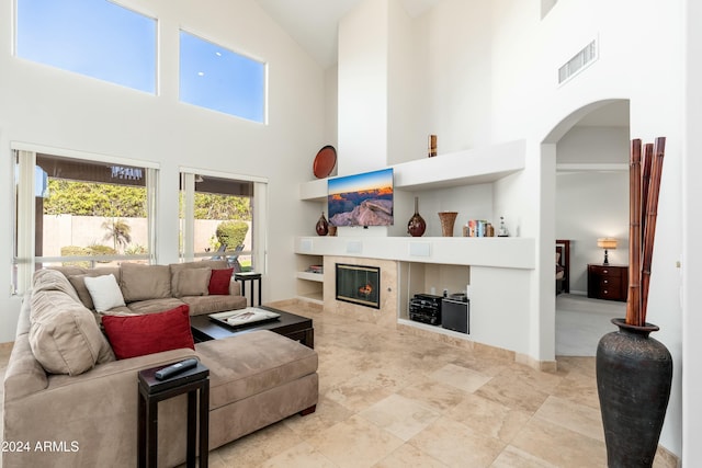 living room with a fireplace and high vaulted ceiling