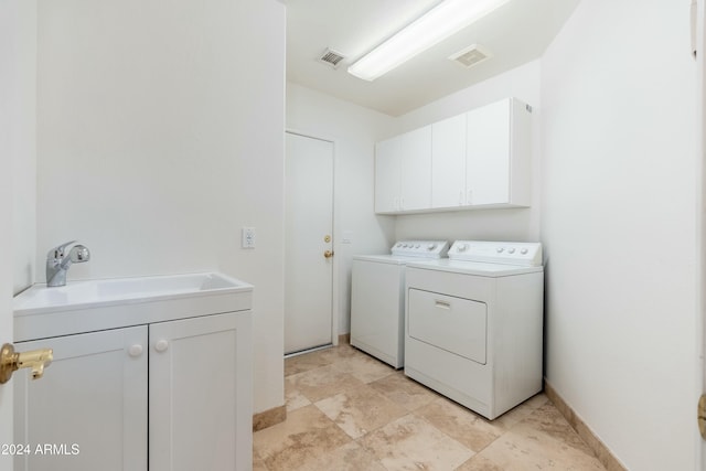 laundry room featuring cabinets, independent washer and dryer, and sink